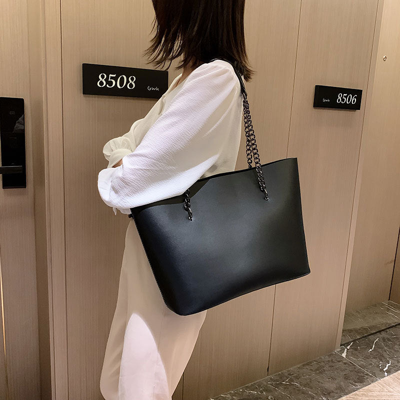 Sac femme noir chic à porter en bandoulière ou épaule, idéal pour un look quotidien et moderne.