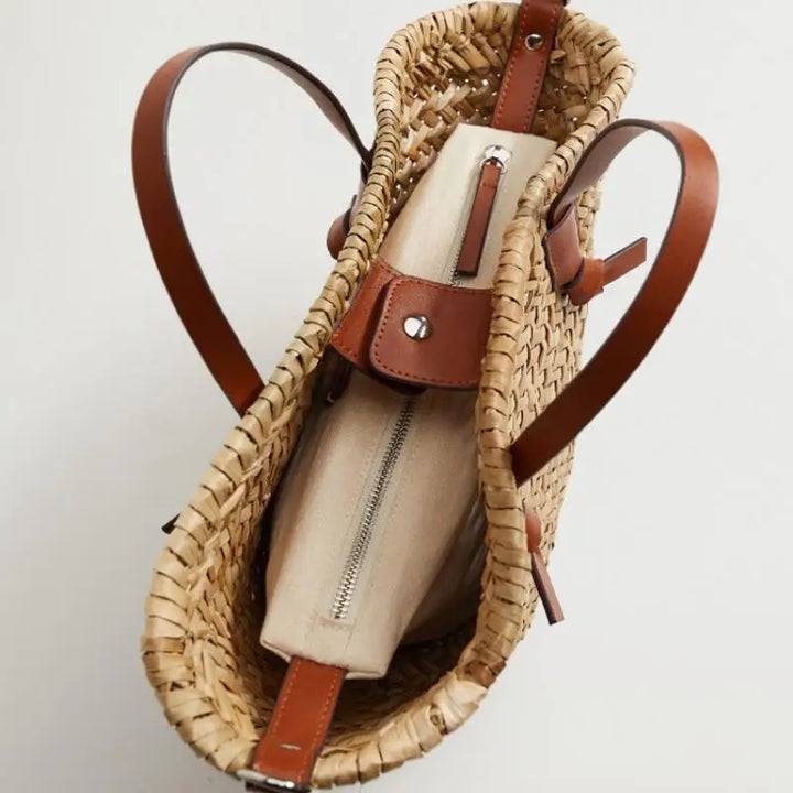 Sac de saison en paille naturelle, avec détails bruns, pour un look estival et authentique.