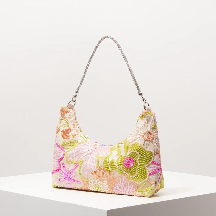 Femme élégante portant le sac à main d'été brodé et scintillant, un accessoire tendance pour un look estival chic.