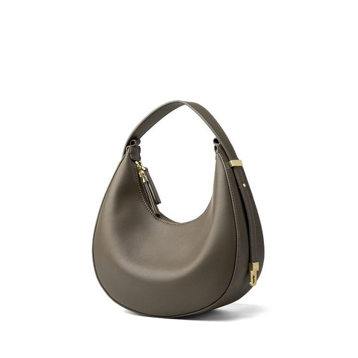 Sac à main demi-lune en cuir bordeaux, un classique intemporel pour femme, idéal pour compléter une tenue élégante.