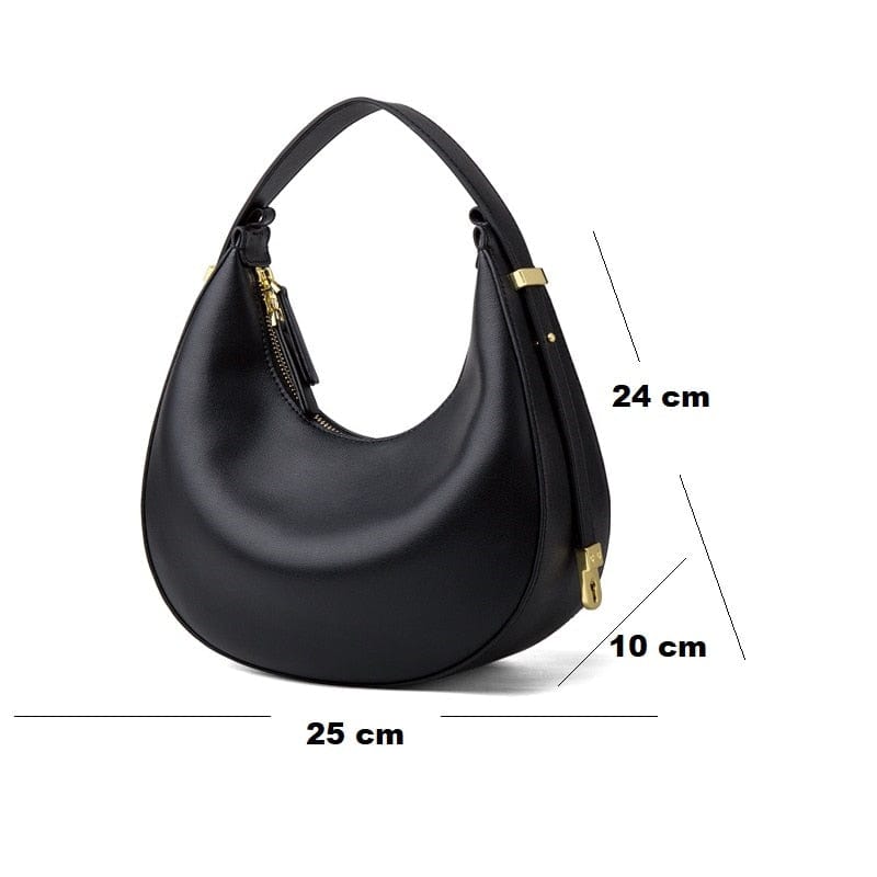 Gros plan d'un sac à main demi-lune en cuir noir, montrant la texture du cuir véritable et les finitions soignées.