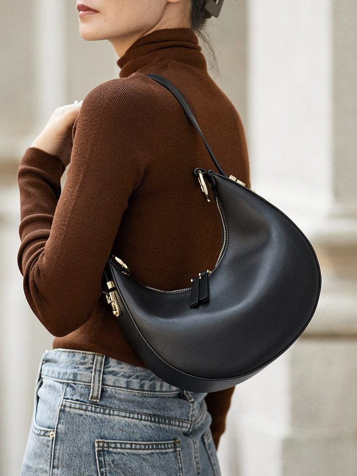 Vue intérieure d'un sac à main demi-lune en cuir véritable, montrant la doublure et les compartiments, maroquinerie femme.