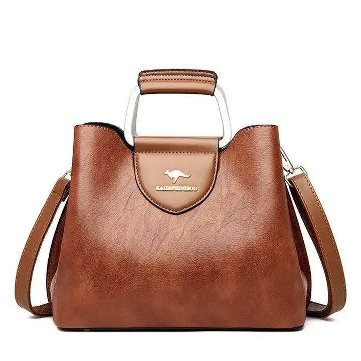 Femme portant un sac à main en cuir bandoulière, idéal pour un look quotidien élégant.