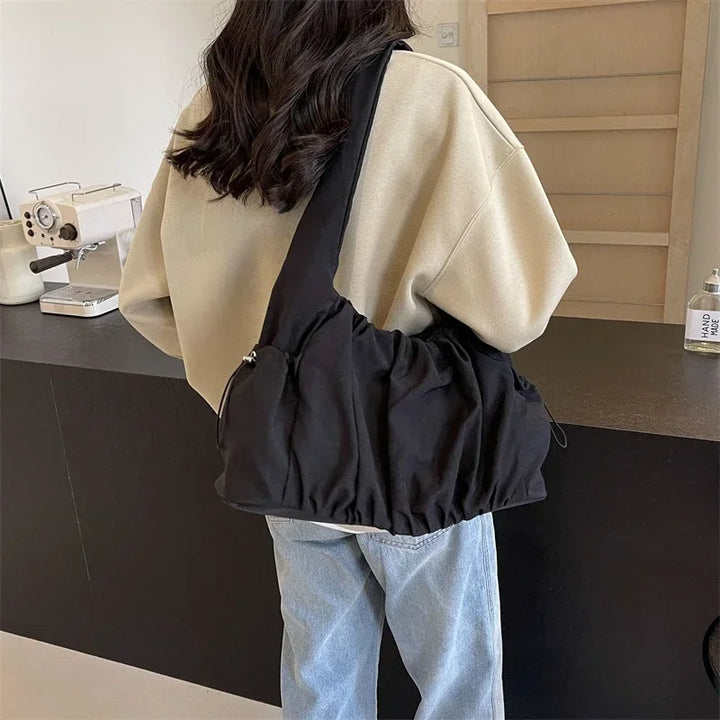 Sac à main en nylon noir pour femme, élégant et pratique, avec bandoulière réglable.