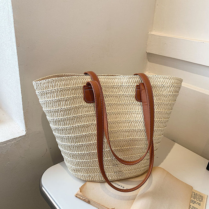 Sac panier en osier naturel et cuir pour femme, style bohème élégant, accessoire de mode estival.