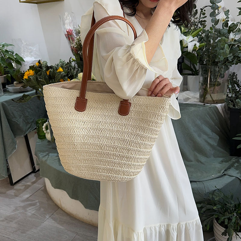 Sac à main femme en osier tressé et détails cuir, style bohème chic, accessoire mode printemps-été.