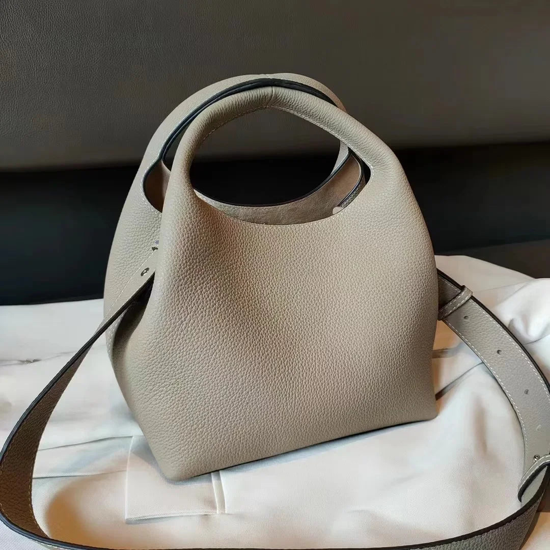 Vue de côté sac à main femme cuir de luxe noir, structure souple, style seau, look sophistiqué et intemporel.