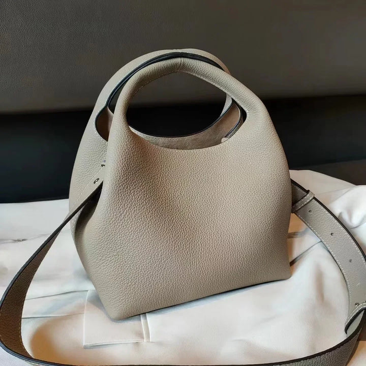 Vue de côté sac à main femme cuir de luxe noir, structure souple, style seau, look sophistiqué et intemporel.