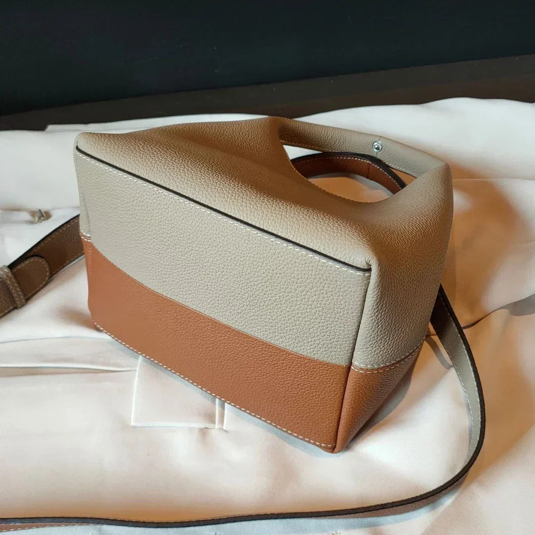 Sac à main femme luxe en cuir noir sur fond neutre, lumière douce, met en valeur les détails raffinés.