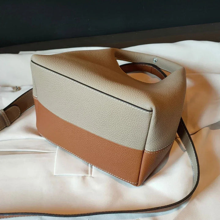 Sac à main femme luxe en cuir noir sur fond neutre, lumière douce, met en valeur les détails raffinés.