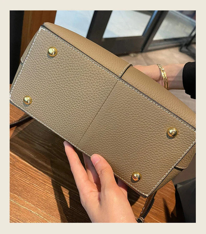 Gros plan sur la texture du cuir grainé de ce sac femme élégant, preuve de sa qualité.
