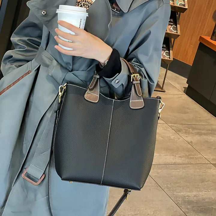 Femme élégante portant un sac à main en cuir grainé, idéal pour un look chic au quotidien.