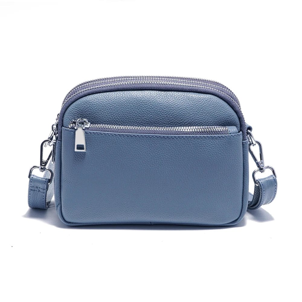 Zoom sur le détail du cuir: sac femme texture lisse, couleur cognac, reflet lumineux, maroquinerie de qualité.