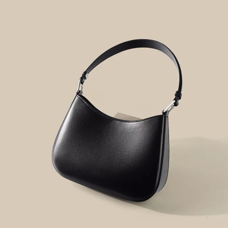 Sac élégant femme en cuir noir, poignée supérieure, bandoulière amovible, idéal pour le quotidien ou les soirées.