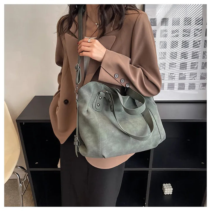 Sac à main en daim élégant porté par une femme, accessoire de mode idéal pour le bureau ou sortie.