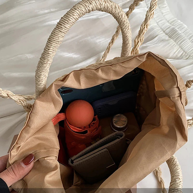 Sac d'été élégant pour femme, en paille tressée, idéal pour compléter un look estival.