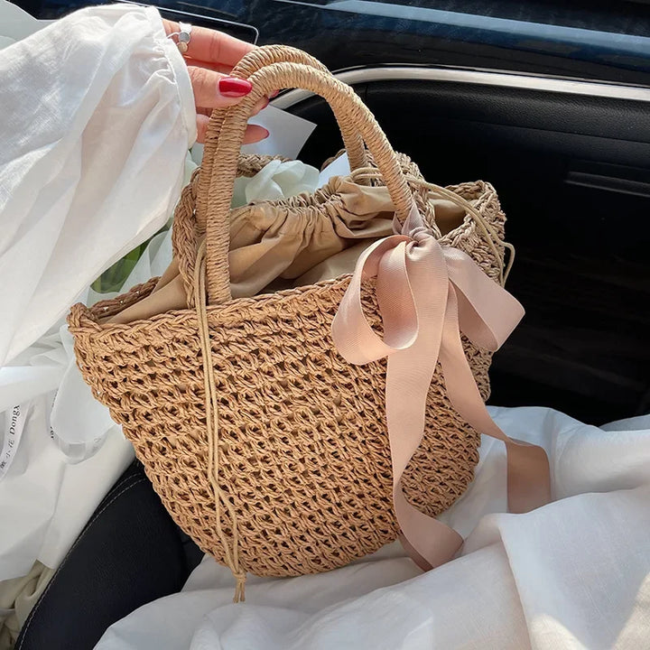 Sac seau élégant en paille naturelle tressée, accessoire de mode estival pour femme.