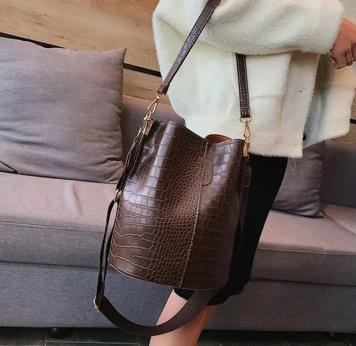 Sac cabas femme moderne en cuir vegan crème, avec bandoulière, combinant style chic et praticité.