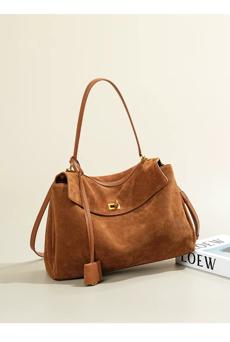 Vue latérale du sac à main femme en daim café, avec bandoulière ajustable, pour plus de confort.