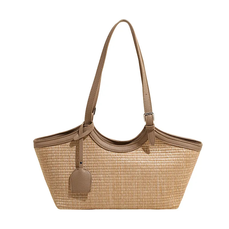 Sac cabas femme estival en paille tressée, anses en similicuir, style chic et décontracté.