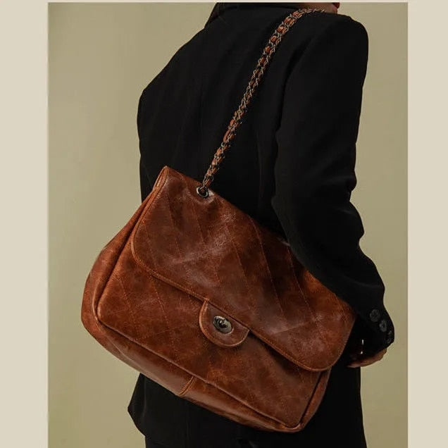 Sac à main femme élégant noir en simili cuir avec anse chaîne dorée. Accessoire chic pour un style tendance.