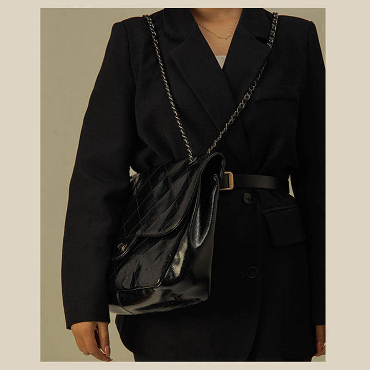 Sac à main chic pour femme en simili cuir noir avec anse chaîne dorée. Parfait comme sac épaule ou bandoulière élégante.