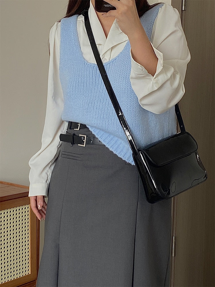Sac à main noir laqué pour femme, design élégant et moderne, idéal pour compléter une tenue chic.