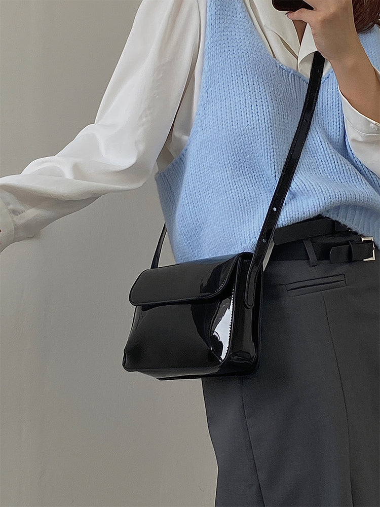 Accessoire de mode: sac à main femme noir brillant et sophistiqué, doté d'une sangle réglable.