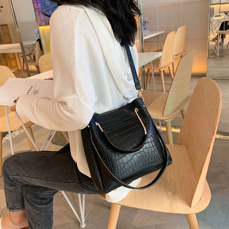 Sac à main tendance femme noir effet croco. Ce sac élégant en matière synthétique est un accessoire de mode.