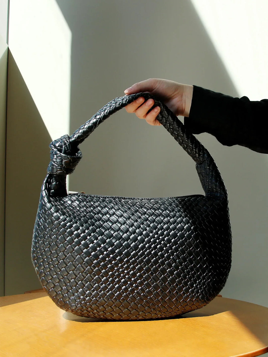 Sac à main femme noir rond tressé élégant en similicuir, idéal pour un look chic au quotidien ou porté épaule.