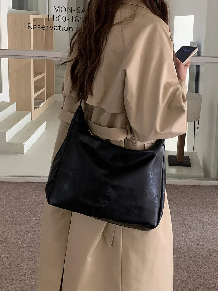 Sac femme moderne en similicuir noir, accessoire polyvalent, idéal pour toutes occasions et tenues.
