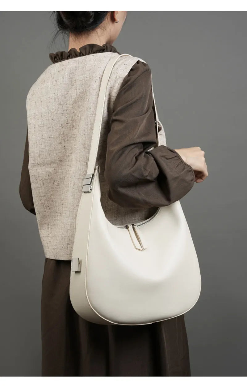 Sac à main hobo en cuir femme, élégamment porté épaule, accessoire chic pour le quotidien.