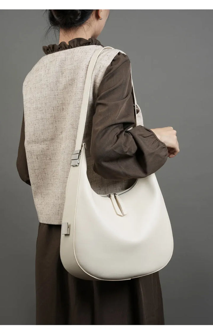 Sac à main hobo en cuir femme, élégamment porté épaule, accessoire chic pour le quotidien.