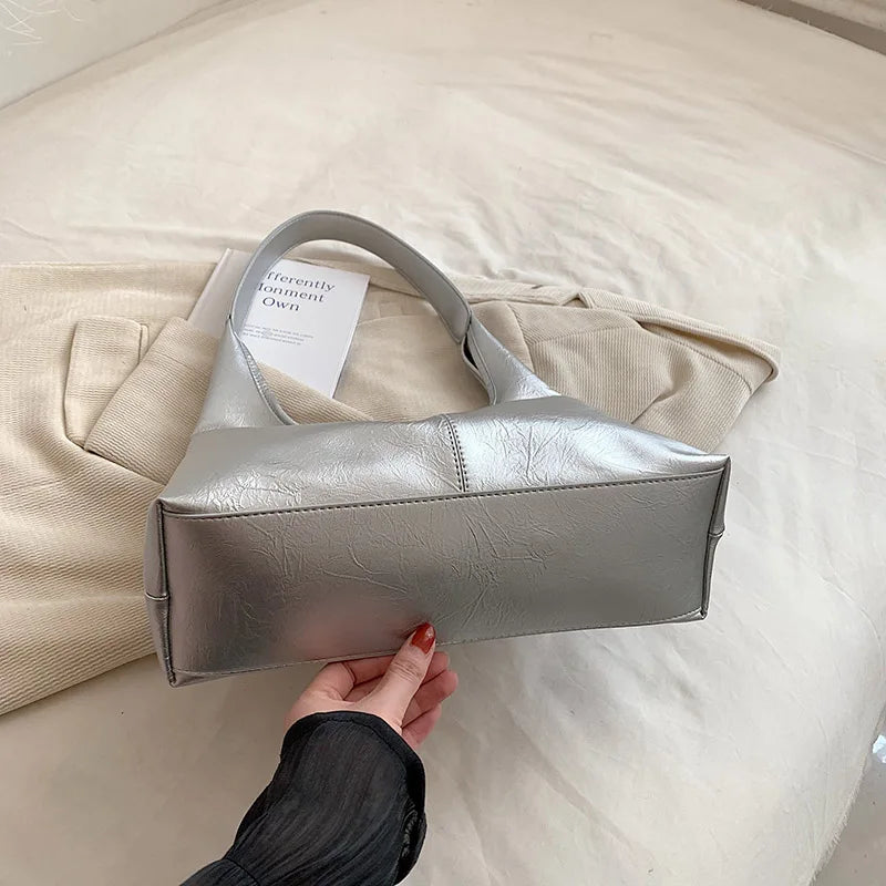 Élégant sac à main hobo argenté pour femme. Similicuir de qualité, tendance et pratique pour un look parfait.