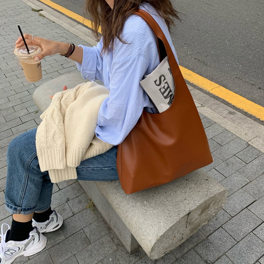 Sac à main élégant pour femmes, couleur camel, porté épaule, en cuir synthétique souple.