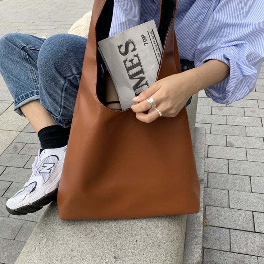Sac camel souple en cuir synthétique, design élégant pour femmes, porté à l'épaule.
