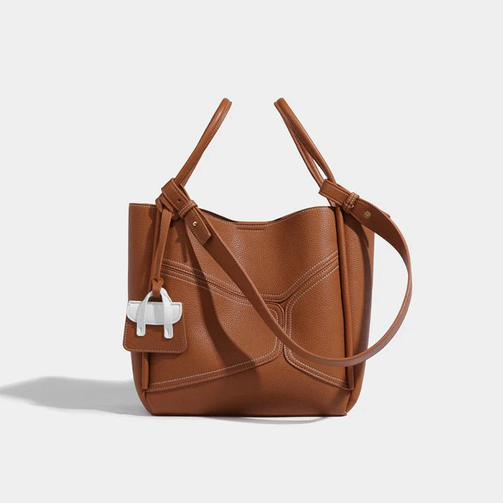 Détail du sac Adelena en cuir, avec surpiqûres fines et quincaillerie dorée.