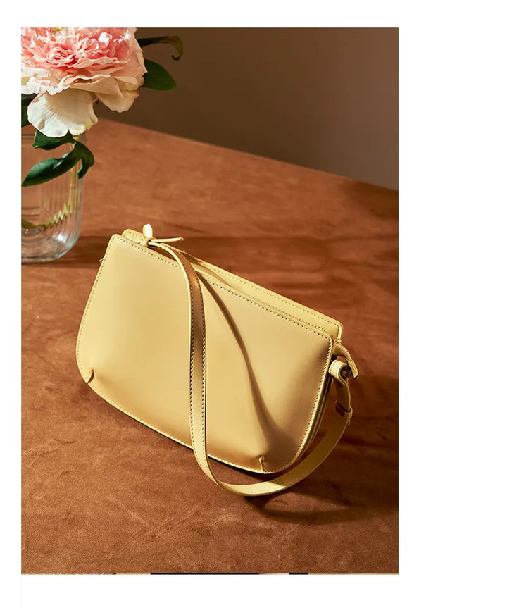 Sac bandoulière rouge en cuir véritable, ouvert, exposant l'intérieur spacieux et la doublure de qualité.