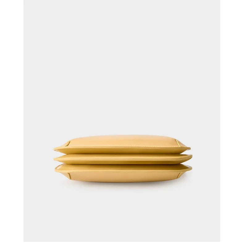 Vue arrière d'un sac à main noir en cuir véritable, mettant en évidence la poche extérieure et les ferrures métalliques.