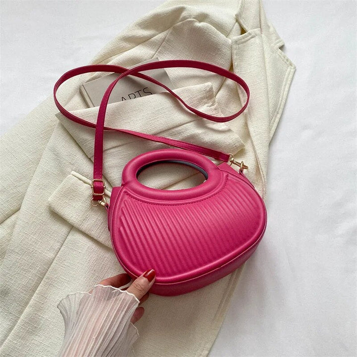 Femme élégante portant un mini sac à main bandoulière matelassé noir, style tendance.