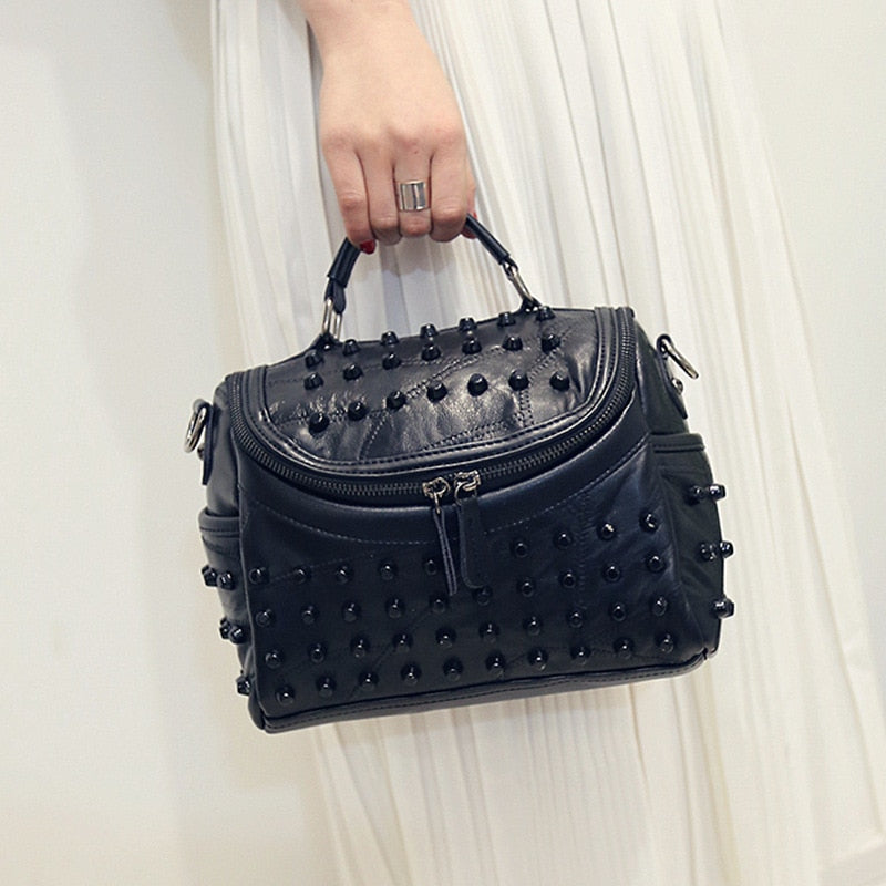 Sac à main femme noir clouté en cuir, idéal pour une touche rock et sophistiquée.
