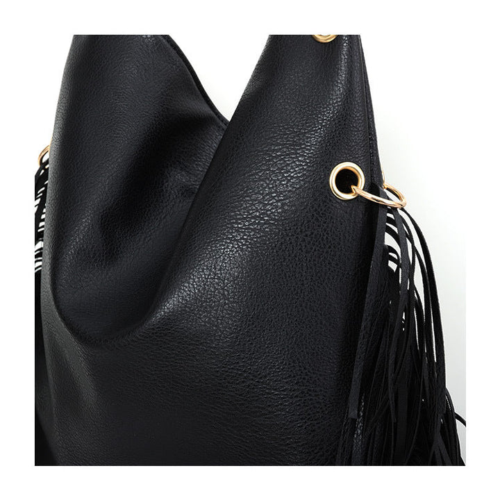 Détail du sac à main femme noir rock chic avec franges et texture cuir PU. Accessoire de mode élégant.
