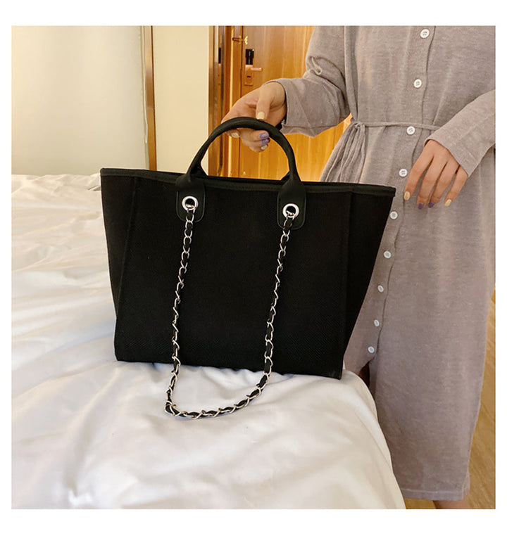 Sac noir classique avec anse chaîne dorée, modèle femme, accessoire élégant et polyvalent