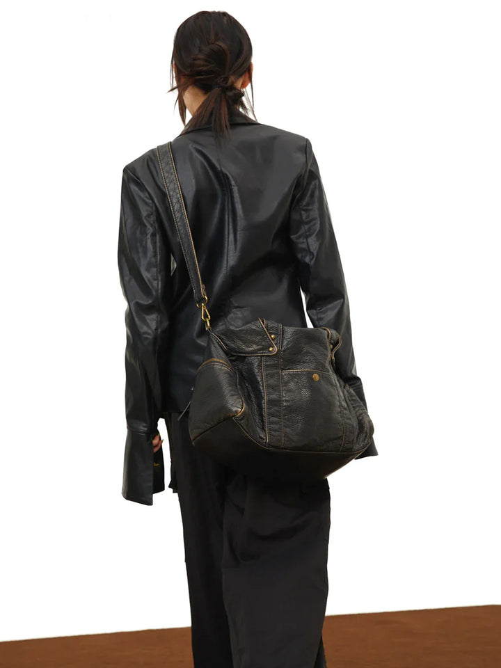 Sac à main noir femme, détail du cuir synthétique. Style vintage, grand et pratique pour étudiante. Mode élégante.