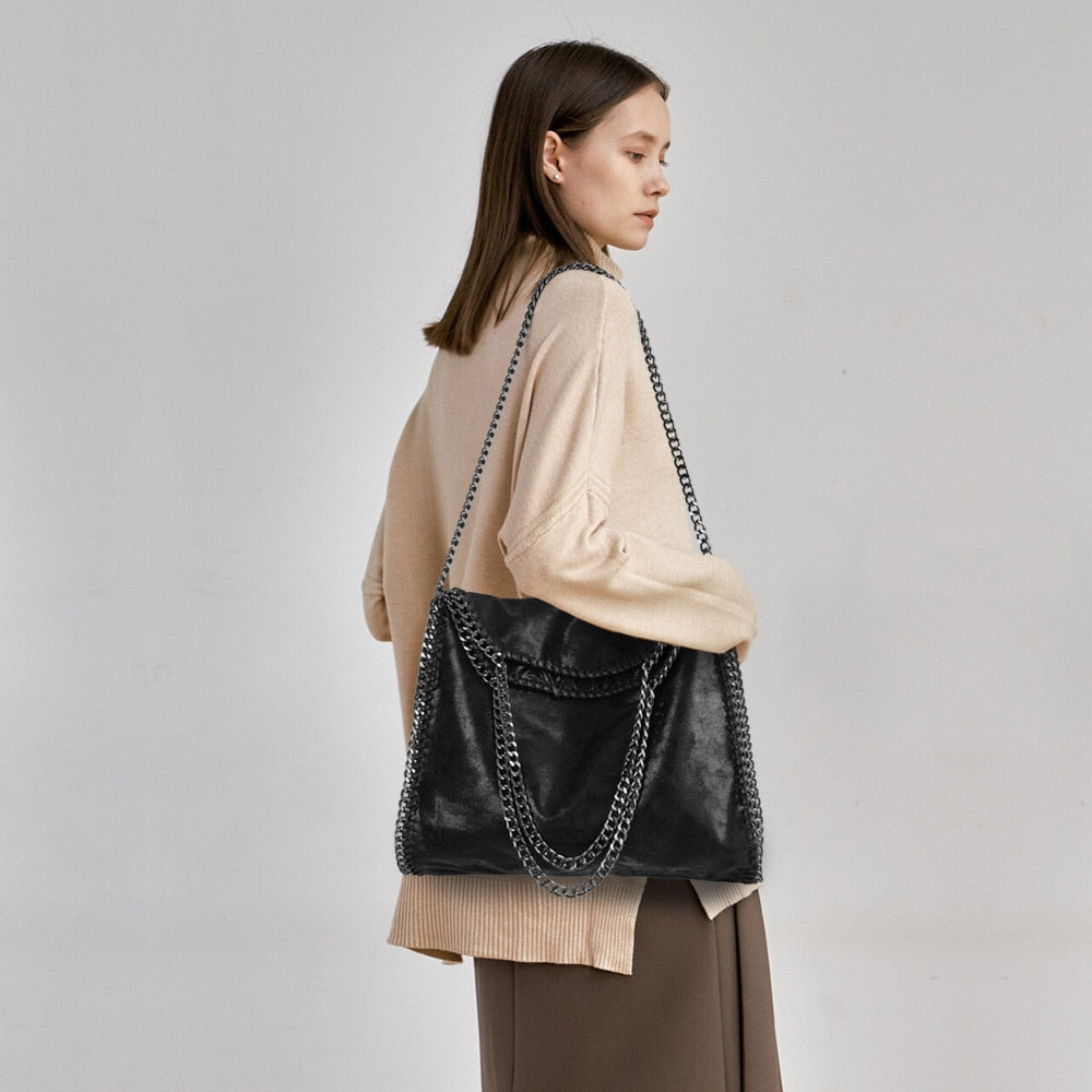 Sac à main femme noir élégant, détails chaîne dorée, en cuir vegan de qualité, accessoire chic.