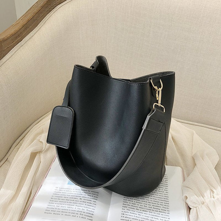 Sac à main épaule noir élégant pour femme, en cuir lisse, avec anse unique et bandoulière amovible, style cabas.