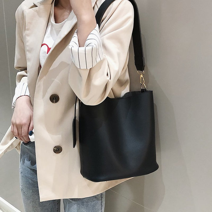 Sac épaule noir classique pour femme, porté main ou épaule, accessoire mode indispensable, en maroquinerie fine.