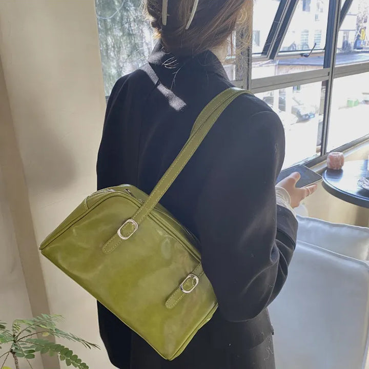 Sac à main chic porté par une femme, accessoire rétro vert kaki, parfait pour un look élégant.
