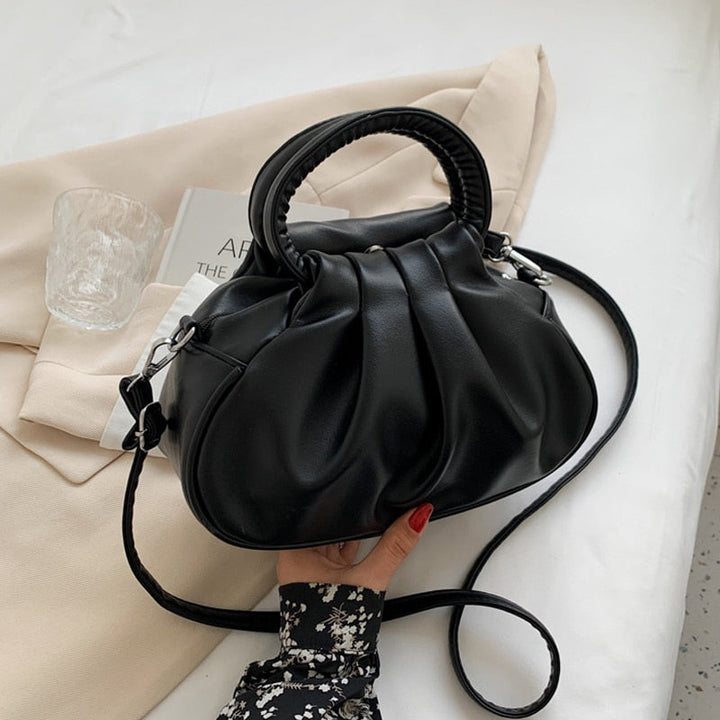 Sac à main rond chic en cuir noir pour femme, parfait pour une soirée élégante, avec bandoulière.