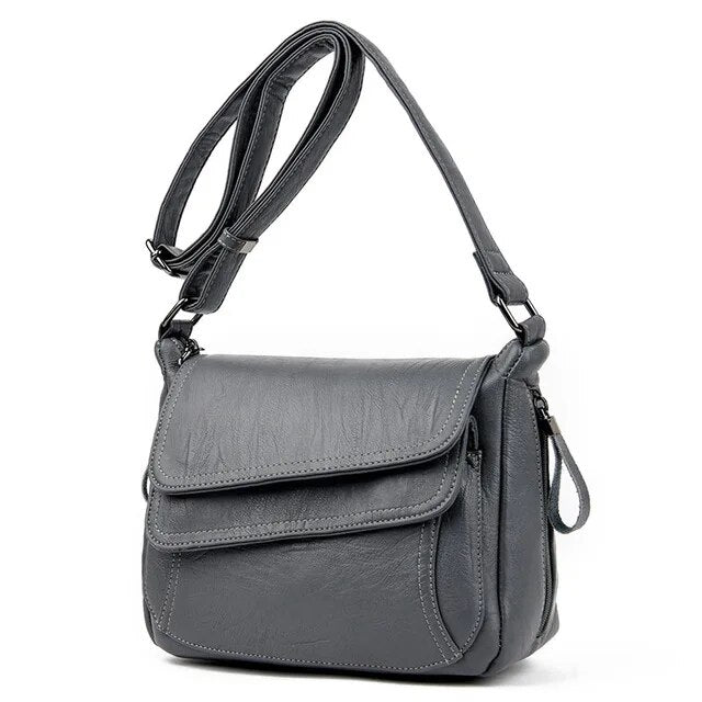 Sac femme noir en similicuir, style besace bandoulière, pour un look chic et intemporel.